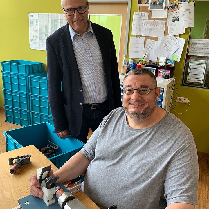 Landtagsvizepräsident Alexander Hold zusammen mit dem Mitarbeiter Marco Gröger an einer Maschine, welche Einzelteile für ein Gardena Kupplungsstück zusammenfügt; Foto: Privat